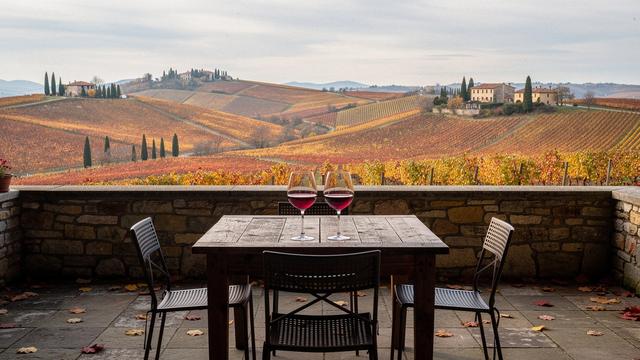Collina piemontese con cantina e calici su terrazza